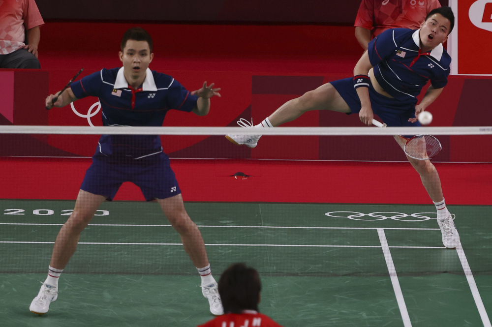 Malaysiau00e2u20acu2122s Aaron Chia hits a shot next to Soh Wooi Yik in their menu00e2u20acu2122s doubles badminton semi-final match against Chinau00e2u20acu2122s Liu Yuchen and Li Junhui at the Musashino Forest Sports Plaza in Tokyo July 30, 2021. u00e2u20acu201d Reuters picn