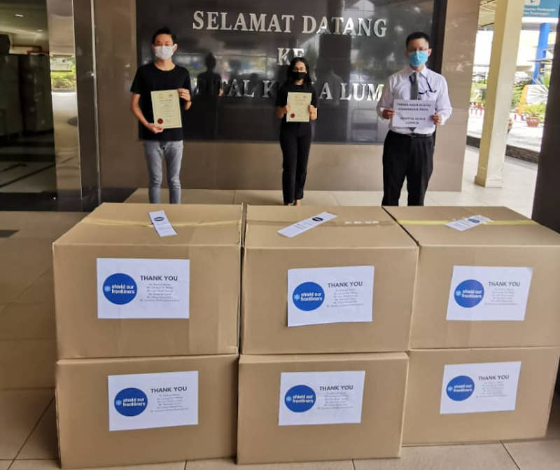 Au Jun Wei (left) and Leong Himn Yau (centre) handing over free face shields to a representative from Hospital Kuala Lumpur last year. Together with Karishma Menon, they are the founders of Feed Selangor. 