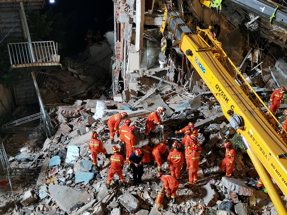 Rescue workers work next to a crane at the site where a hotel building collapsed in Suzhou, Jiangsu province, China July 12, 2021. u00e2u20acu2022 cnsphoto via Reuters