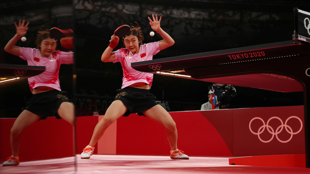 Chen Meng of China in action against Sun Yingsha of China, as she is reflected in a scoreboard display screen during the womenu00e2u20acu2122s singles gold medal match at the Tokyo Metropolitan Gymnasium in Tokyo, July 29, 2021. u00e2u20acu201d Reuters picnn