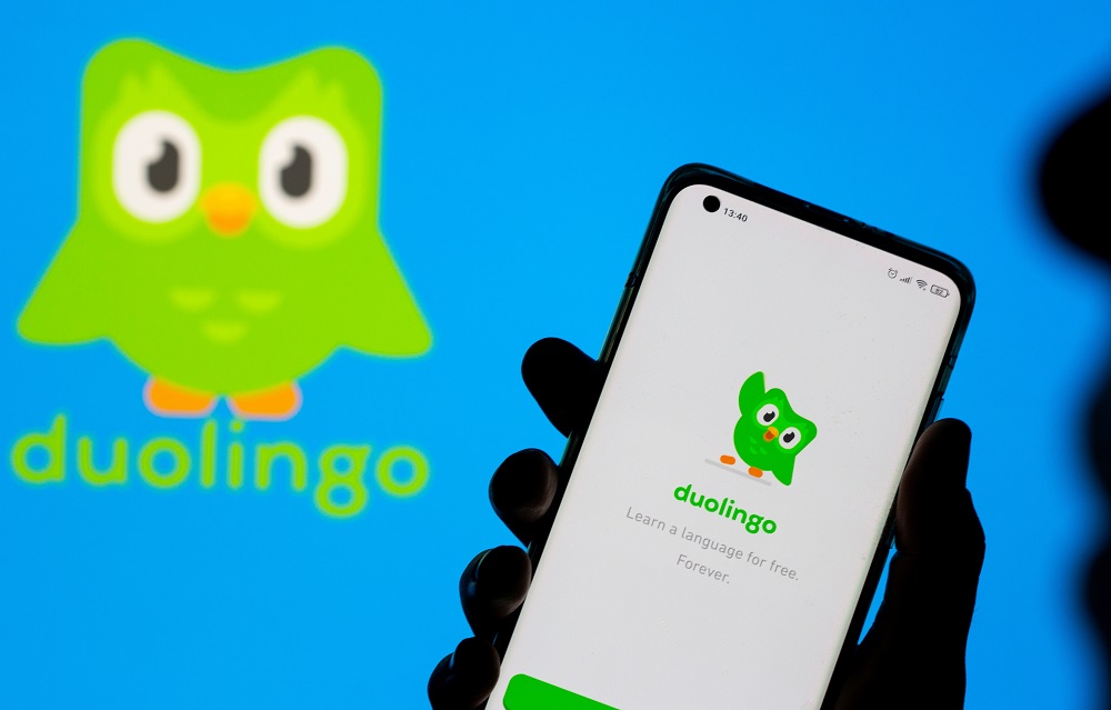 Woman with her smartphone poses in front of displayed Duolingo logo in this illustration taken, June 29, 2021. u00e2u20acu2022 Reuters pic