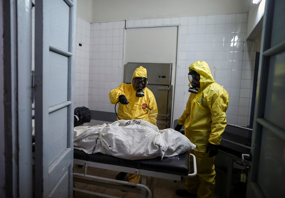Gaston Rusichi and Oscar Oliva, members of the Department of High Risk Units (DUAR), disinfect a body of a person who died from Covid-19) in a morgue, in Cordoba, Argentina July 11, 2021. u00e2u20acu2022 Reuters pic