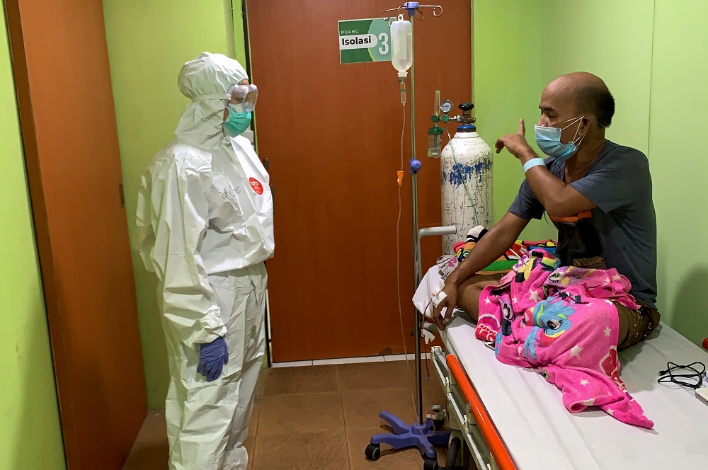 Cheras Sjarfi, a 28-year-old doctor, talks with a patient during her shift inside an isolation room at a government-run hospital, as Covid-19 cases surges in Jakarta July 1, 2021. u00e2u20acu2022 Reuters pic