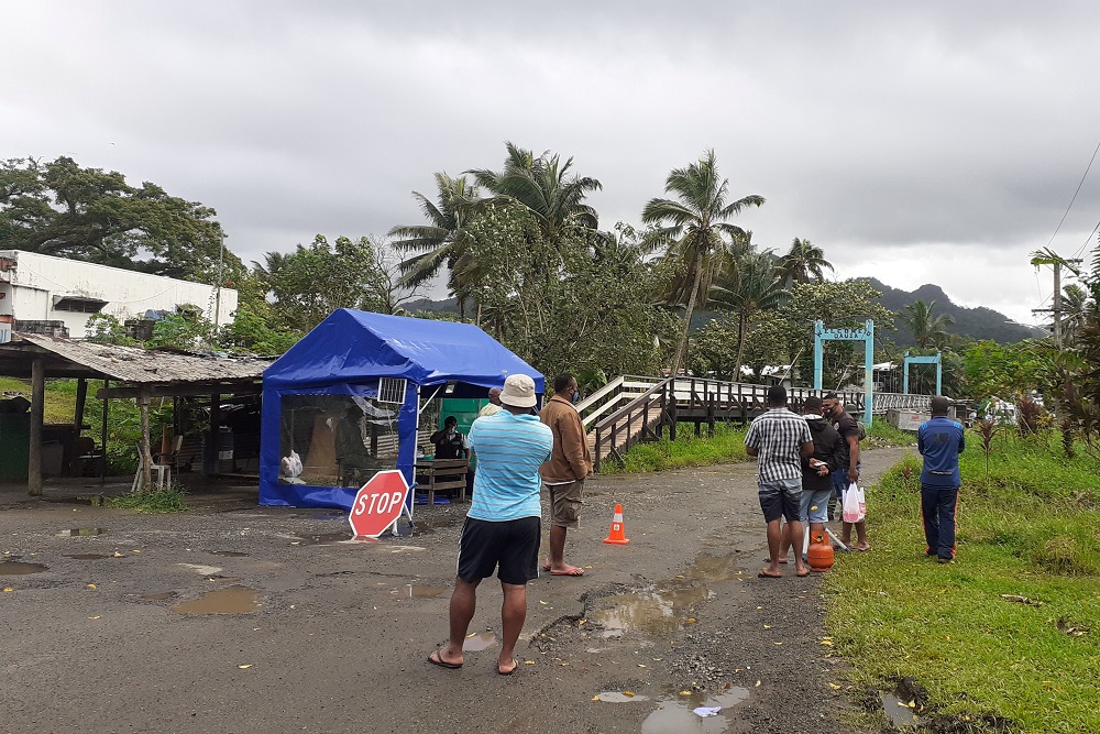 Family members wait at the entrance to a village settlement to deliver food to relatives that are in lockdown in Lami, Fiji, June 26, 2021. u00e2u20acu2022 Reuters file pic