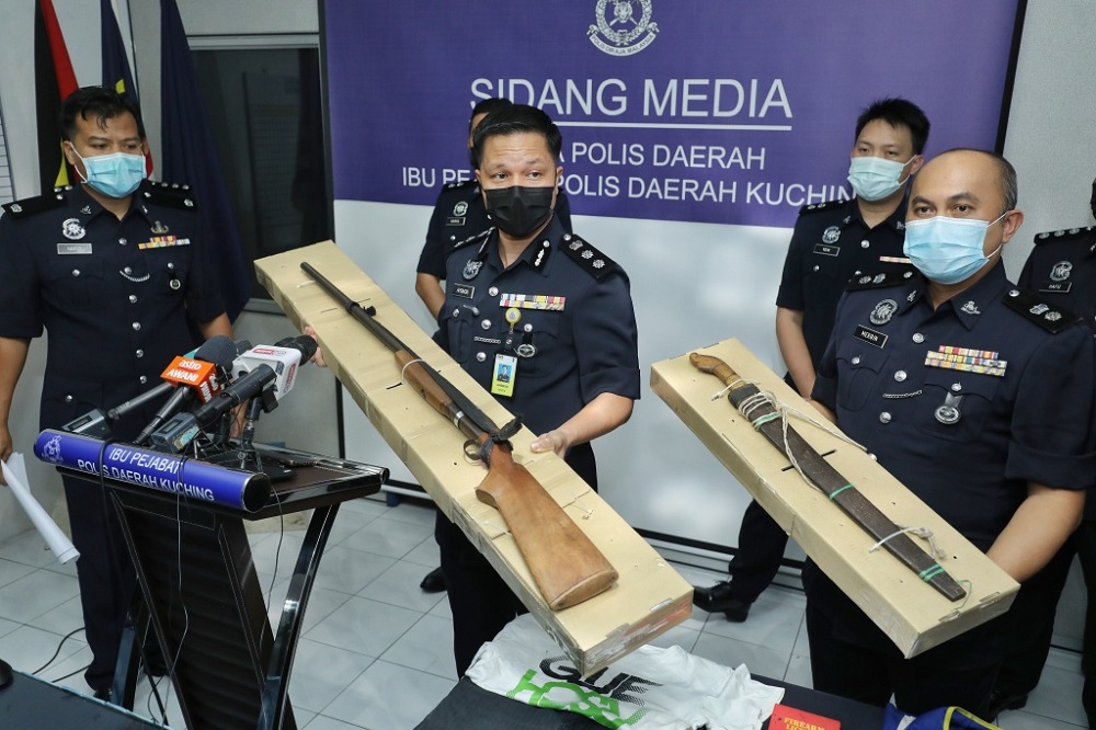 Ahsmon (centre) and his deputy Supt Merbin Lisa (right) show the weapons seized from the two suspects. u00e2u20acu201d Picture by Chimon Upon via Borneo Post Online
