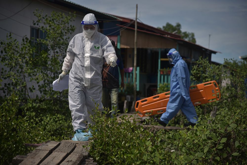 Health personnel carefully crossing a small bridge while conducting Covid-19 active case detection (ACD) at the Refugee Community Settlement Scheme in Kampung Muslim, Labuan, July 4, 2021. u00e2u20acu201d Bernama pic