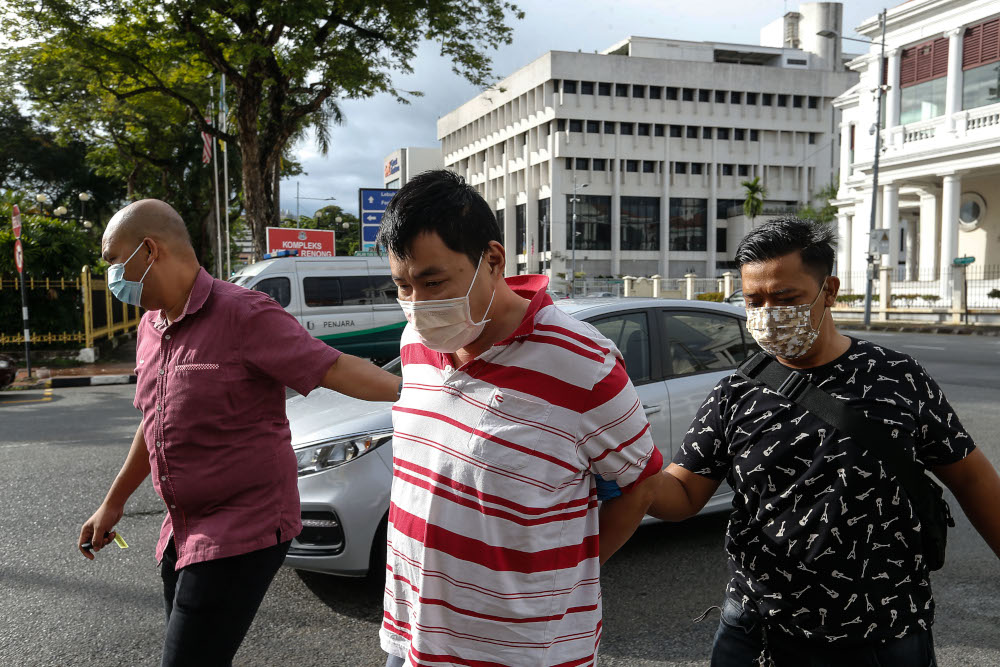 Lim Siong Aik, 44 pictured escorted by the police to face a whopping 300 charges at George Town Magistratesu00e2u20acu2122 Court, July 12, 2021. u00e2u20acu201d Picture by Sayuti Zainudin