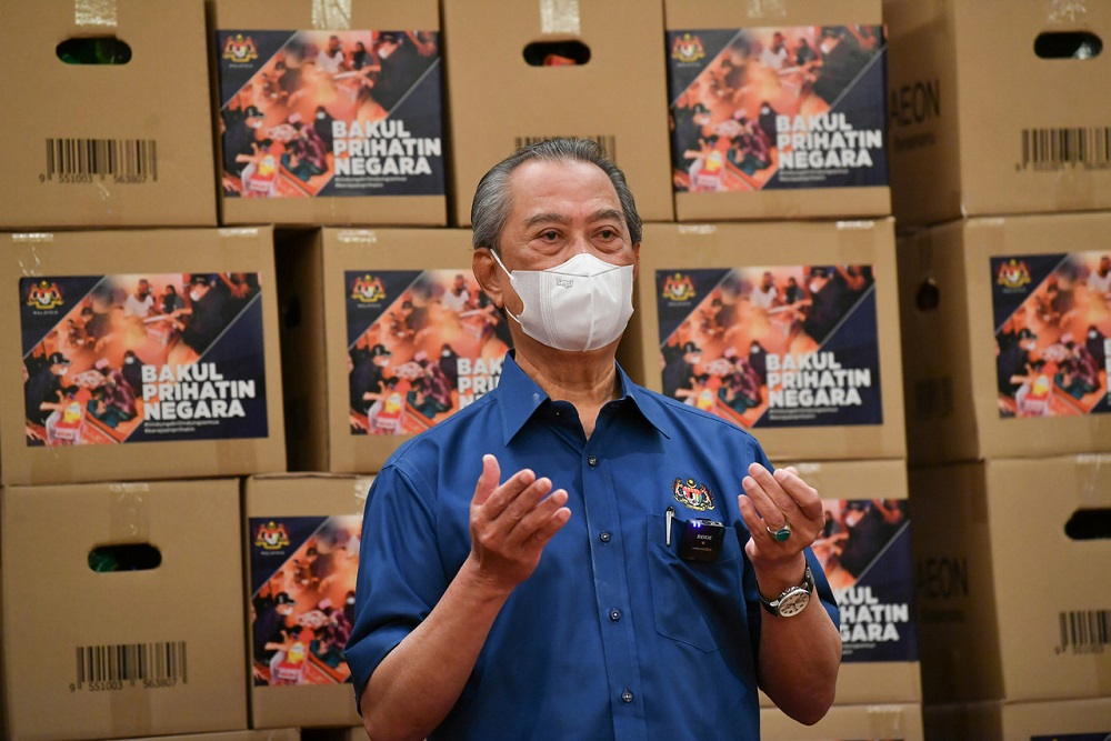 Prime Minister Tan Sri Muhyiddin Yassin says a prayer after visiting the collection and distribution centre for the programme at Dewan Perdana Nur at the KPWKM in Putrajaya July 15, 2021. u00e2u20acu2022 Bernama pic