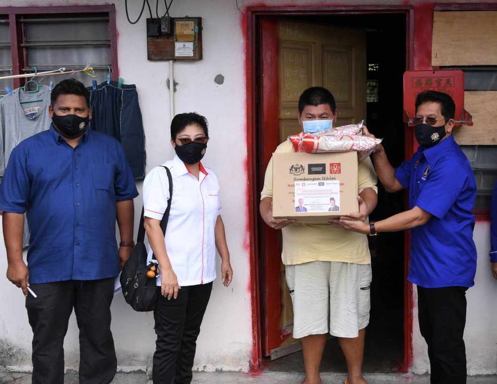 Sabak Bernam MP Datuk Mohd Fasiah Mohd Fakeh delivers a food basket to Lee Choon Wah (2nd right) in Sabak Bernam, July 5, 2021. u00e2u20acu201d Bernama picnn