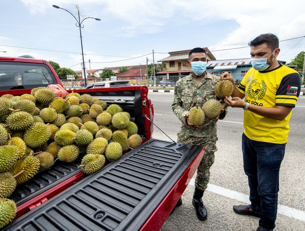 MZ Gold chief executive officer Murtadhatumizi Mustapha distributes 1200kg tonnes of durians at drive-through giveaway in Pasir Pekan, Kota Bharu, July 24, 2021. u00e2u20acu201d Bernama pic
