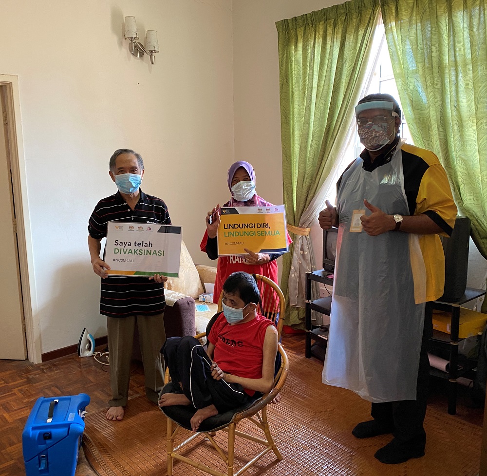 National Cancer Society Malaysia managing director Dr Murallitharan M with a patient and family during the house-to-house vaccination programme. u00e2u20acu2022 Picture courtesy of National Cancer Society Malaysia