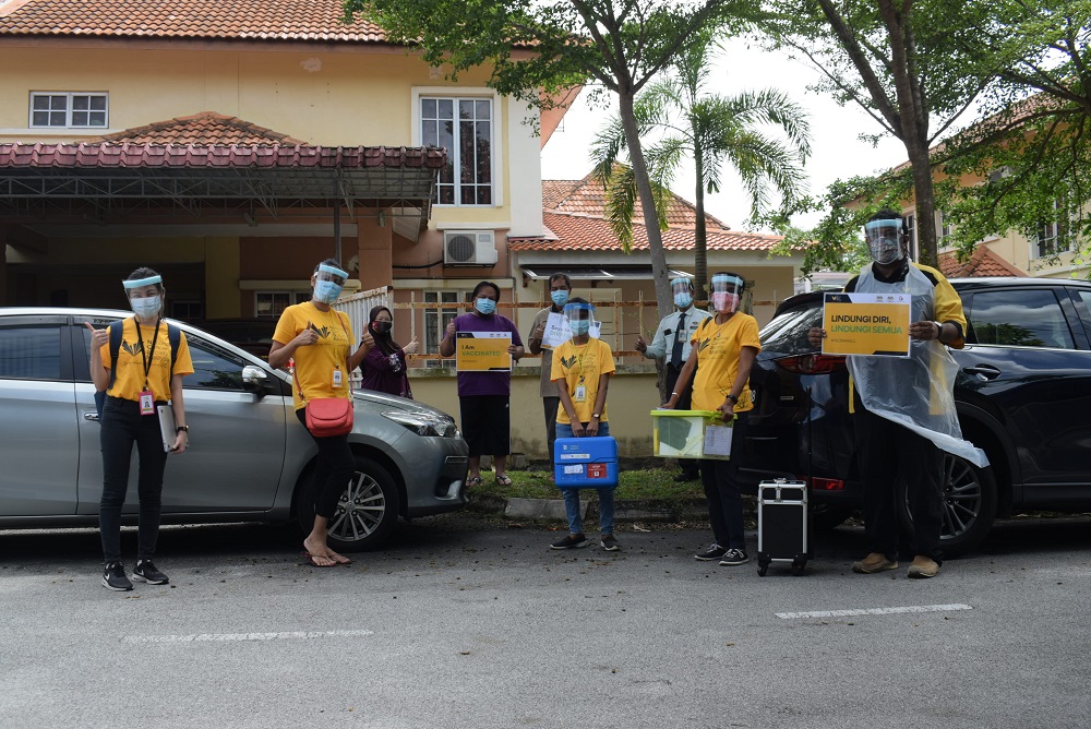 The team with a patient’s family during the house-to-house vaccination programme. ― Picture courtesy of National Cancer Society Malaysia