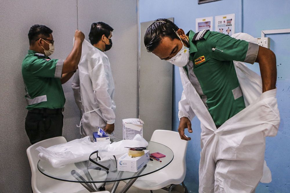 Paramedics don Personal Protection Equipment as they prepare to respond to a Covid-19 related emergency at the company's headquarters in Kuala Lumpur July 5, 2021. 