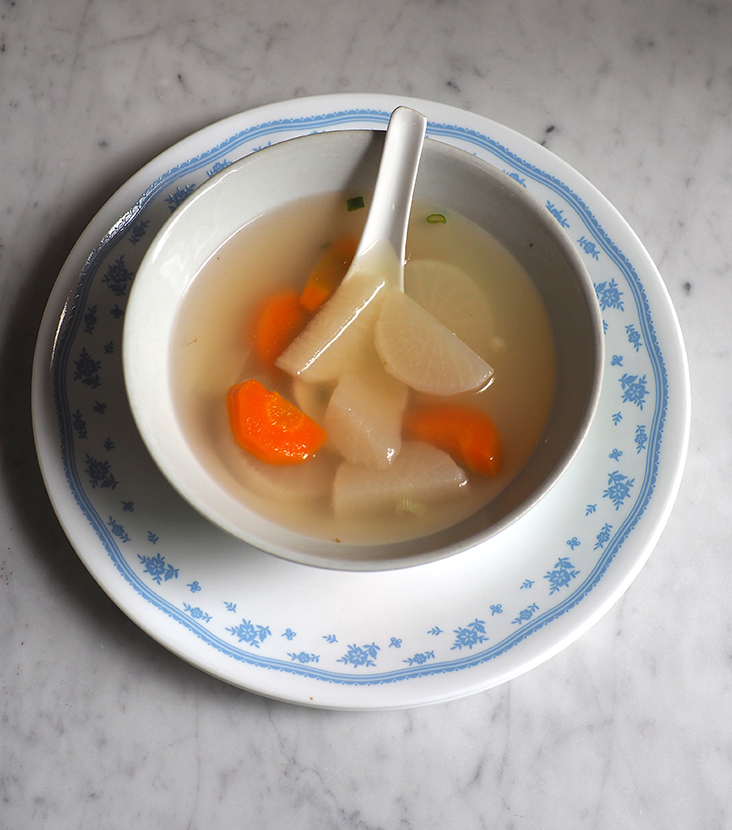 The soup served with the rice is sweet with tender pieces of carrots and white radish