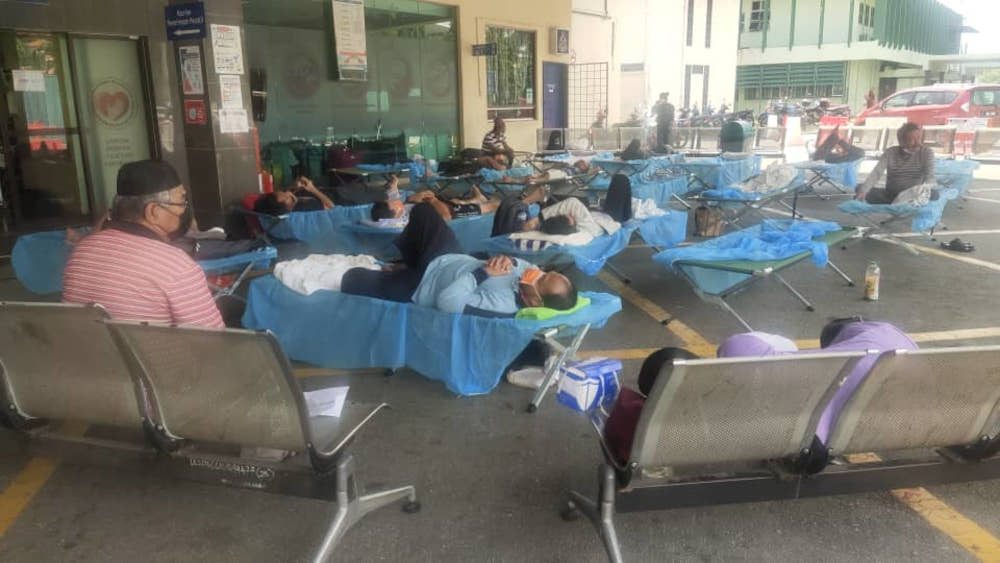 Around a dozen patients lie in folding cots outside the entrance of HTARu00e2u20acu2122s Emergency Department. u00e2u20acu201d Picture courtesy of Charles Santiago
