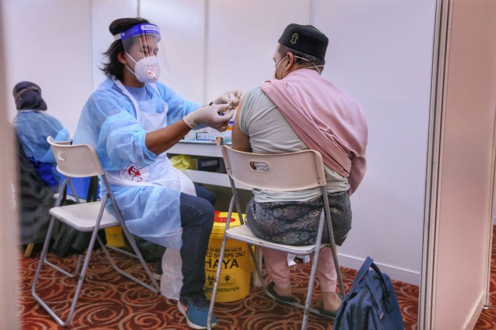 A man, dressed in baju melayu, receives his Covid-19 jab at the World Trade Centre vaccination centre in Kuala Lumpur on Hari Raya Aidiladha July 20, 2021. u00e2u20acu201d Picture by Ahmad Zamzahuri