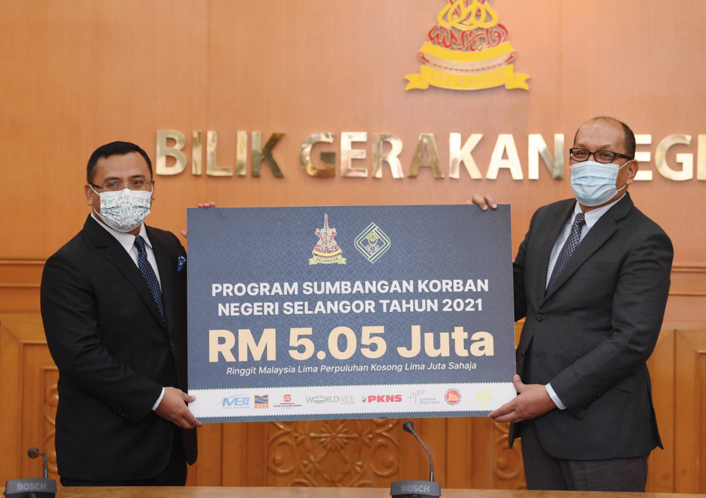 Selangor MB Datuk Seri Amirudin Shari hands over a contribution under the Sumbangan Korban Negeri Selangor programme to state exco Izham Hashim, July 7, 2021. u00e2u20acu201d Bernama pic 