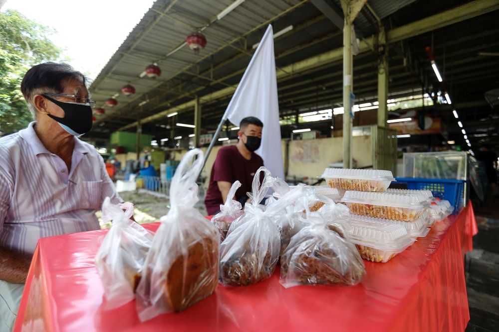 Hawkers from the Batu Lanchang Food Court are giving away 20 packets of economy rice and 20 packets of noodles for free to help those in need July 2, 2021. u00e2u20acu201d Picture by Sayuti Zainudin