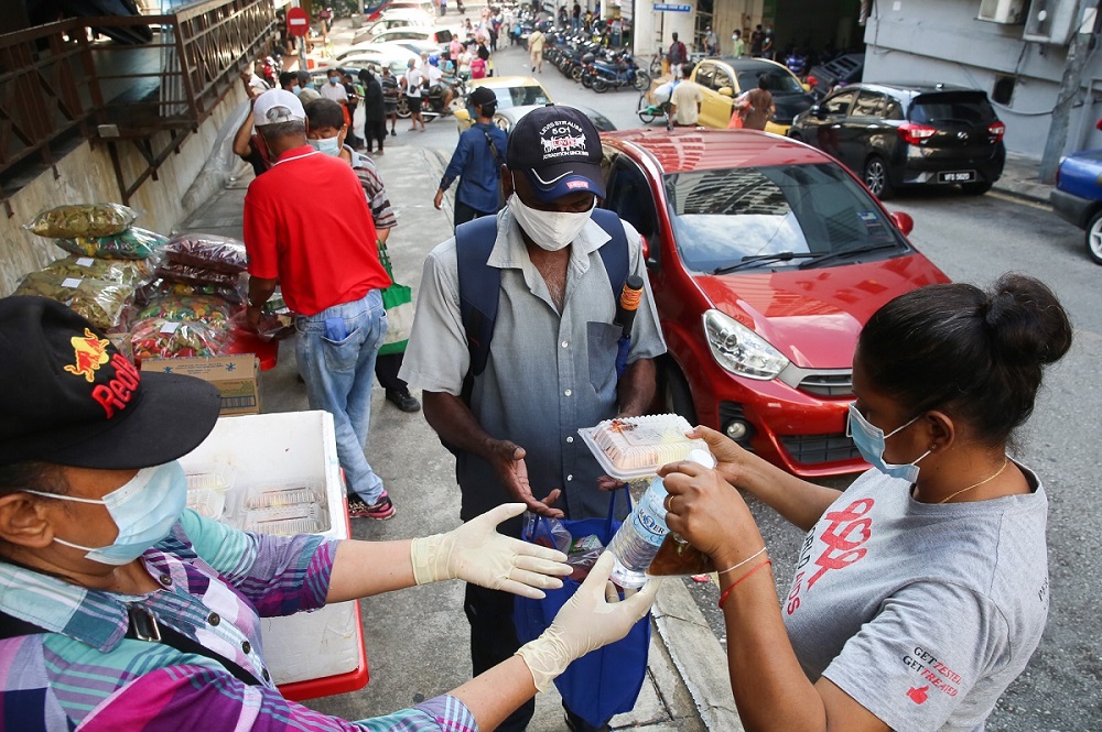 PPKUM president Elisha Kor Krishnan (right) distributing free meals to the needy in Chow Kit. ― Picture by Choo Choy May 