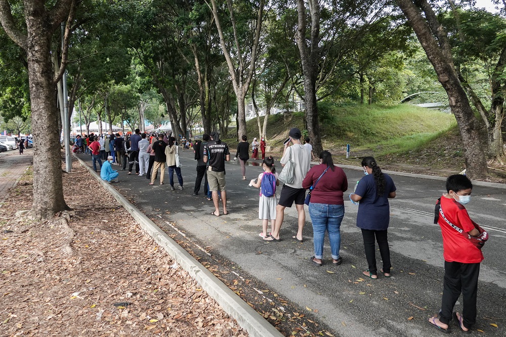 People line up before entering the Covid Assessment Centre (CAC) at Stadium Malawati in Shah Alam July 10, 2021. u00e2u20acu2022 Picture by Miera Zulyana