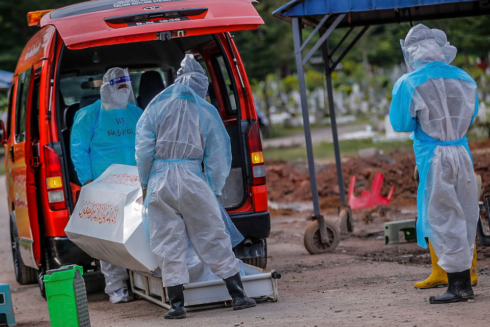 Health workers in personal protective equipment bury the body of a Covid-19 victim at the Muslim cemetery in Section 21, Shah Alam, July 10, 2021. u00e2u20acu2022 Picture by Hari Anggara