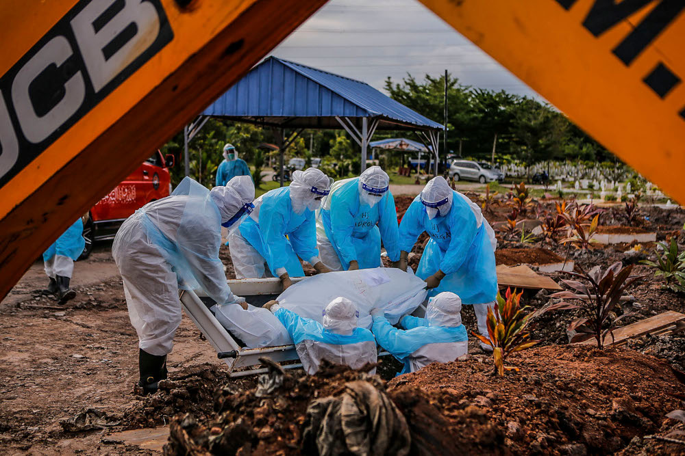 Health workers in personal protective equipment bury the body of a Covid-19 victim at the Muslim cemetery in Section 21, Shah Alam, July 10, 2021. u00e2u20acu2022 Picture by Hari Anggara
