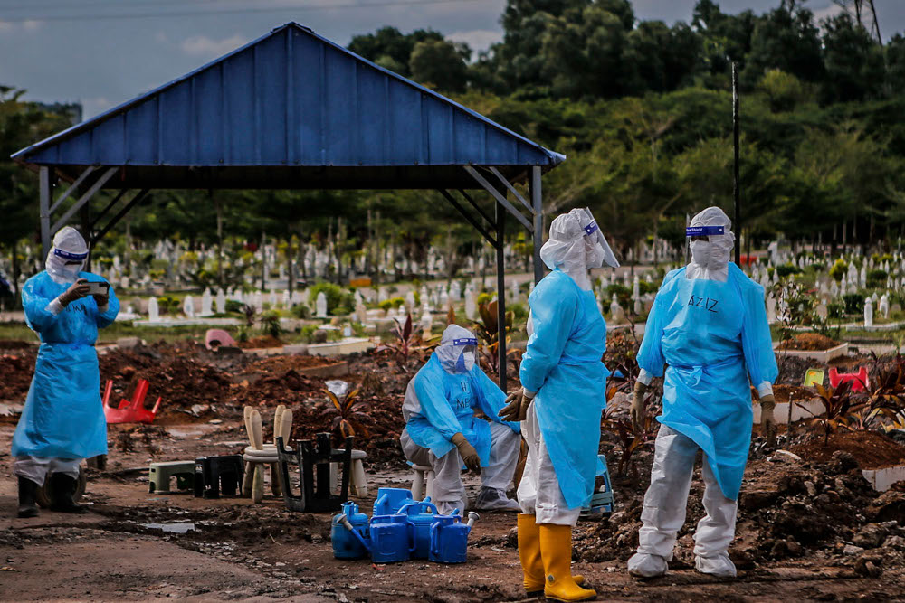 Health workers in personal protective equipment after burying the body of a Covid-19 victim at the Muslim cemetery in Section 21, Shah Alam, July 10, 2021. u00e2u20acu2022 Picture by Hari Anggara