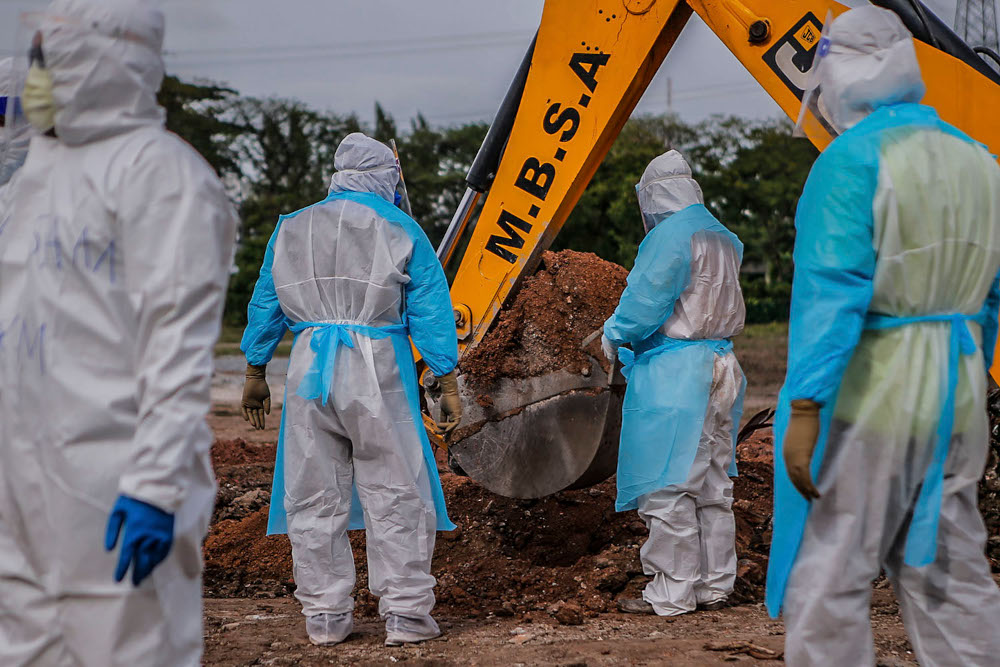Health workers in personal protective equipment bury the body of a Covid-19 victim at the Muslim cemetery in Section 21, Shah Alam, July 10, 2021. u00e2u20acu2022 Picture by Hari Anggara
