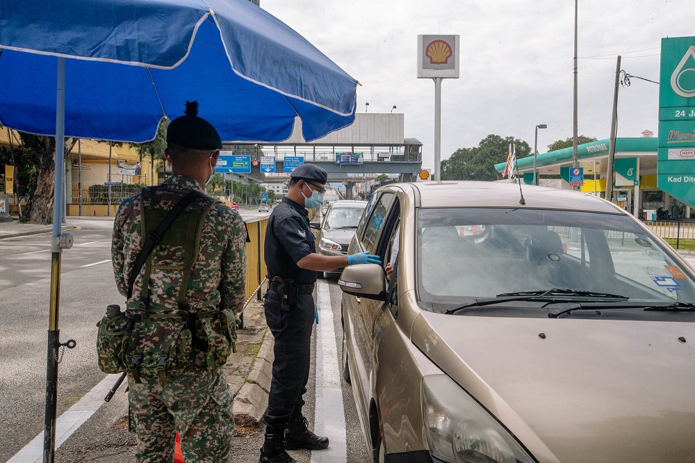 Police and army personnel conducting checks at a roadblock in Jalan Ampang during the enhanced movement control order (EMCO) July 3, 2021. u00e2u20acu2022 Picture by Firdaus Latif
