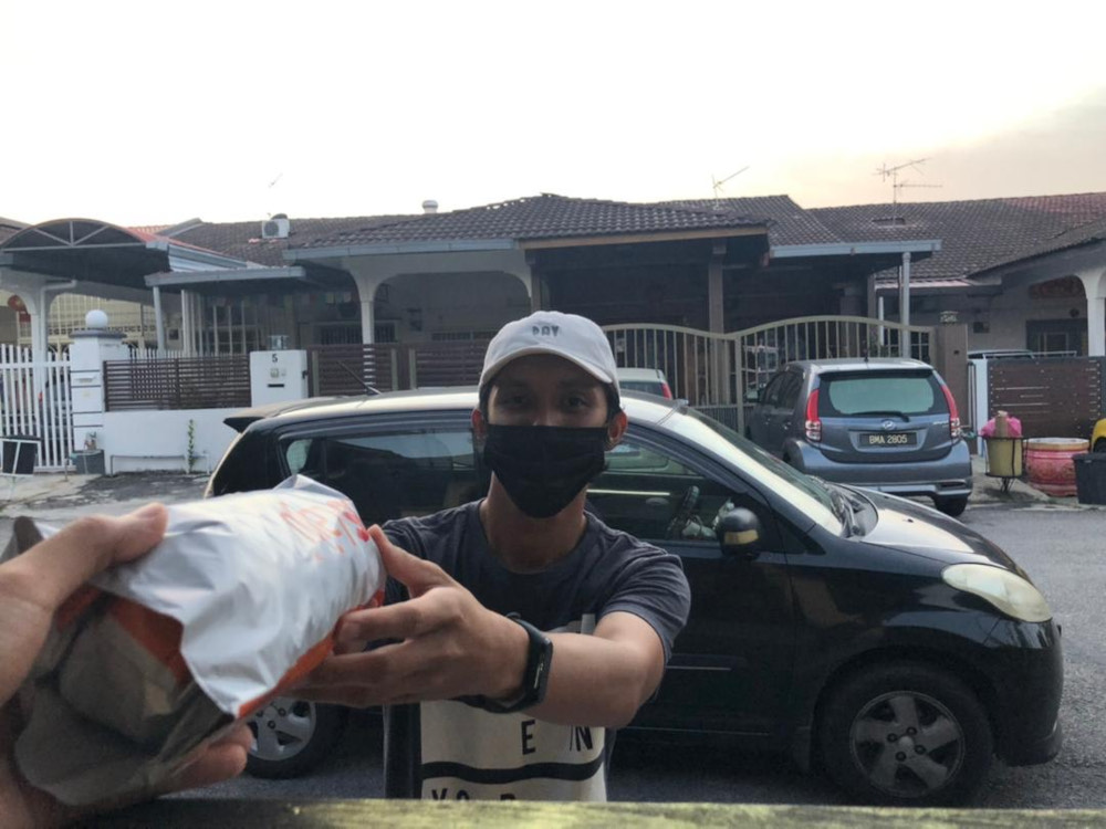 Qayyum delivering parcels for Lalamove despite working as a full-time assistant manager at a petrol station. u00e2u20acu201d Picture by Qayyum Gustaf