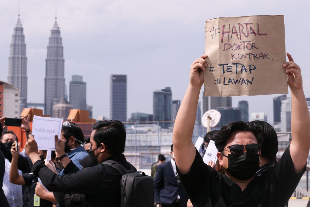 Contract doctors hold aloft placards demanding equal treatment as they go on strike at the Kuala Lumpur Hospital July 26, 2021. u00e2u20acu201d Picture by Ahmad Zamzahuri