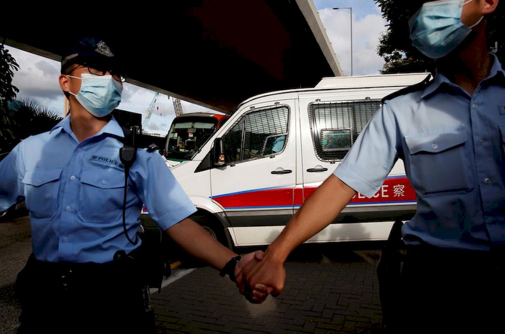 Police officers escort a prison van which is carrying Tong Ying-kit, the first person charged under the new national security law, as he leaves West Kowloon Magistratesu00e2u20acu2122 Courts, in Hong Kong, China July 6, 2020. u00e2u20acu201d Reuters pic