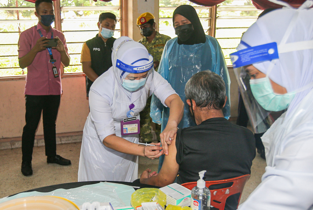 A homeless man receives the Covid-19 vaccination at the temporary homeless centre in Dewan PBSM in Jalan Kompleks Sukan, Ipoh, July 14, 2021. u00e2u20acu201d Picture by Farhan Najib