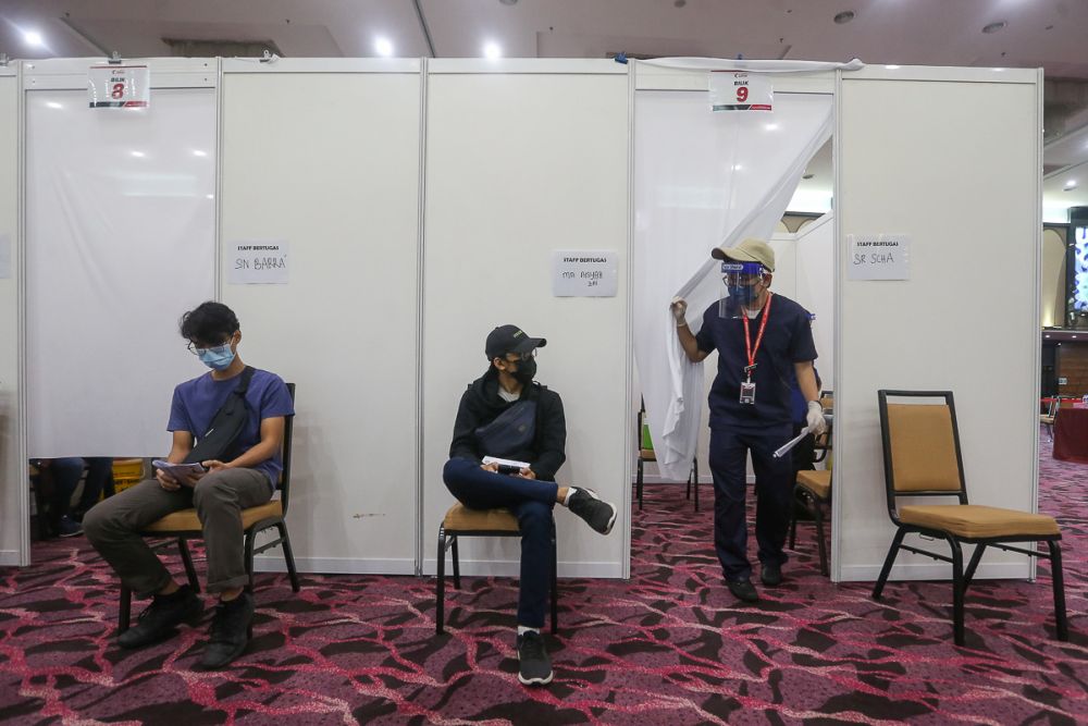 People wait to receive their Covid-19 jab at the IDCC Convention Centre in Shah Alam July 14, 2021. u00e2u20acu201d Picture by Yusof Mat Isa