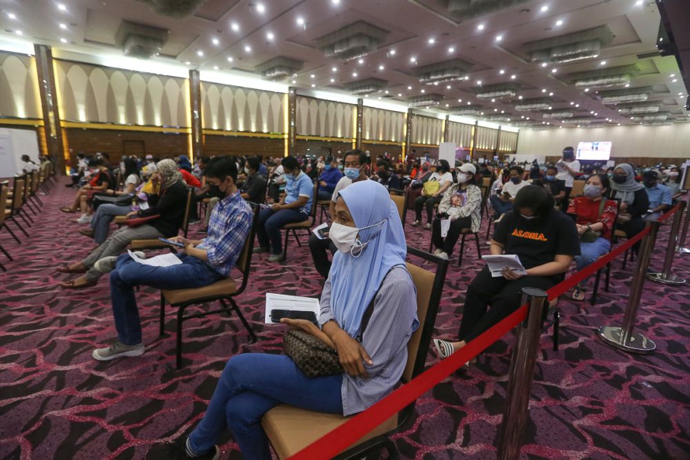 People wait to receive their Covid-19 jab at the IDCC Convention Centre in Shah Alam July 14, 2021. u00e2u20acu201d Picture by Yusof Mat Isa
