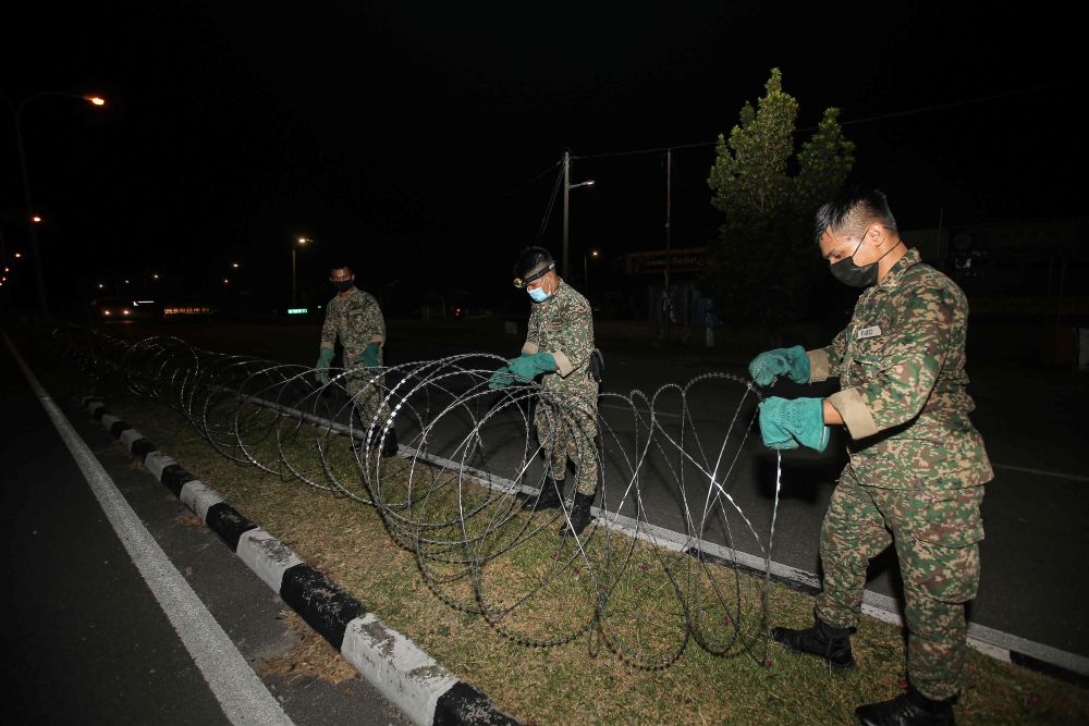 Armed Forces personnel erect barbed wire fencing in Medan Klebang Restu, Ipoh July 26, 2021. u00e2u20acu201d Picture by Farhan Najibn