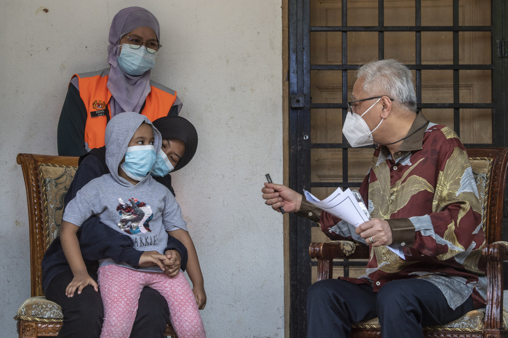 Deputy Prime Minister Datuk Seri Ismail Sabri Yaakob speaks Nazurah Nabilah Benyajeed and her sister Nur Qurratu Ain Nabilah after visiting the eight siblings who lost their parents to Covid-19 in Bukit Beruntung, July 22, 2021. u00e2u20acu201d Bernama pic 