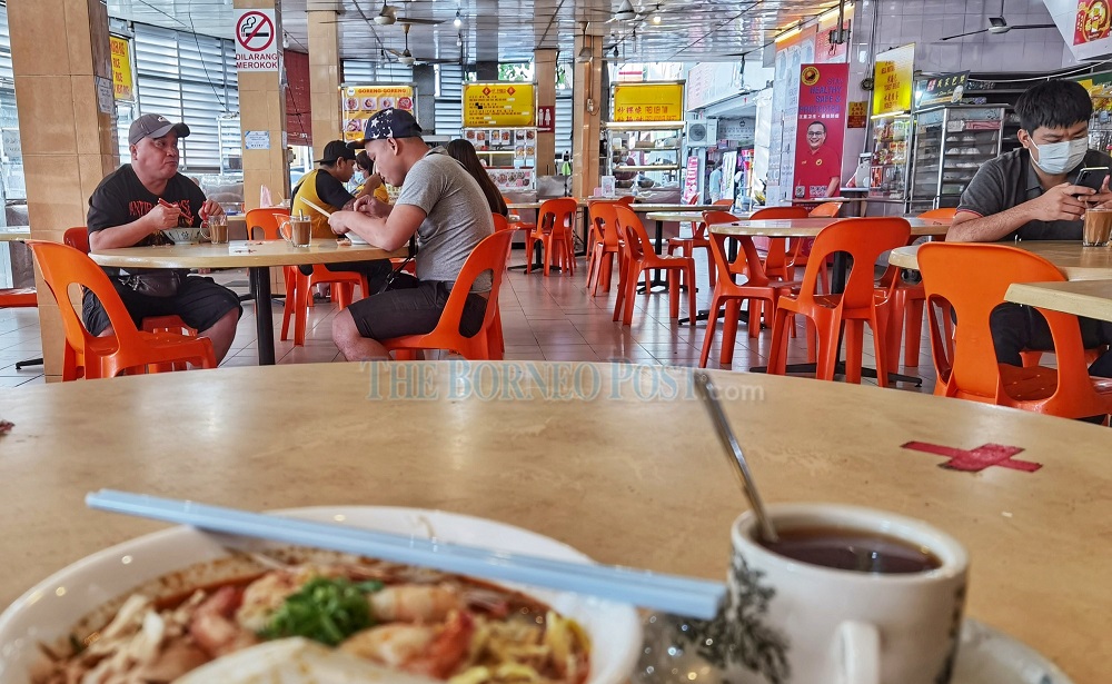 Customers adhering to the two-person per table ruling. — Picture by Chimon Upon via Borneo Post Online