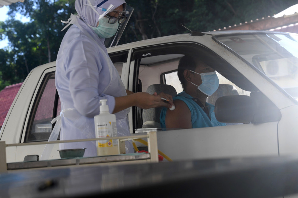 A vaccine recipient getting his Covid-19 jab at the Padang Terap District and Land Office drive-thru vaccination programme, July 1, 2021. u00e2u20acu201d Bernama pic 