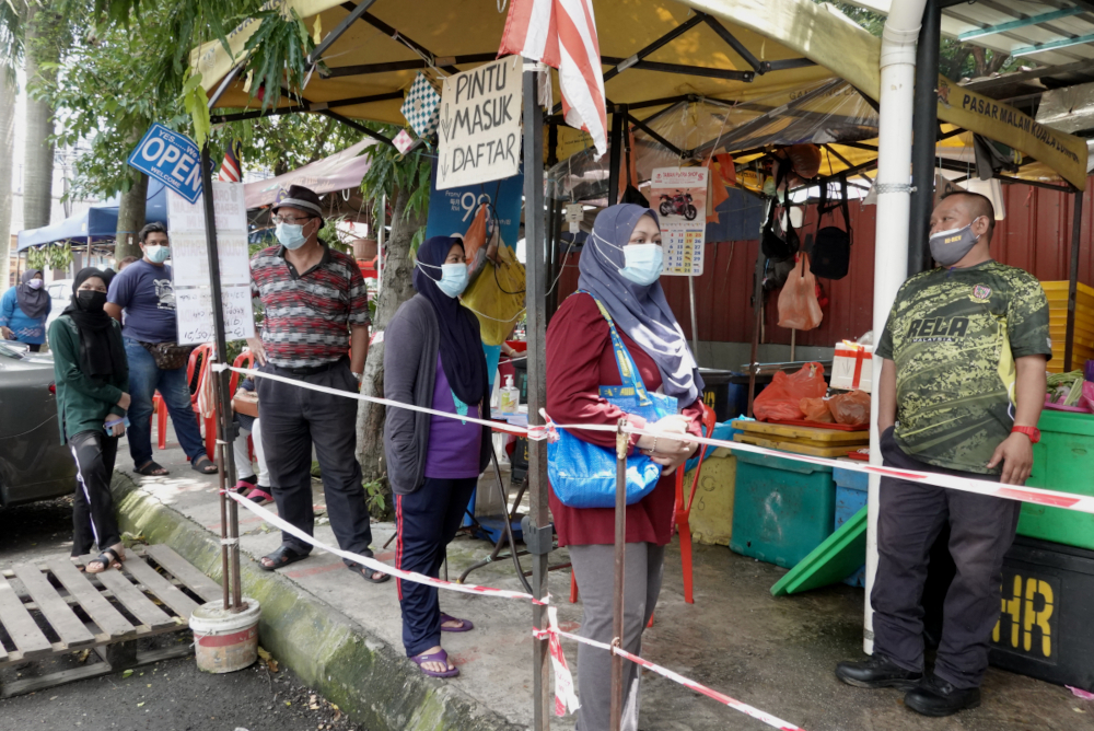 Residents of Kerinchi PPR stand in line to get provisions, July 2, 2021. — Picture by Miera Zulyana
