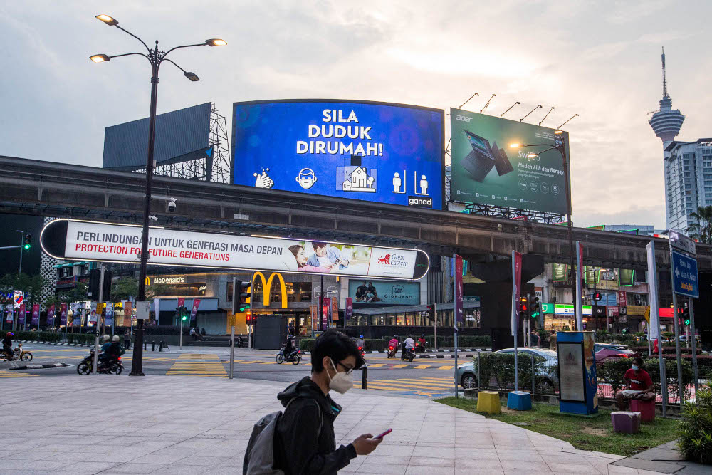 A pedestrian wearing a face mask walks on the street in Kuala Lumpur July 9, 2021. u00e2u20acu201d Picture by Firdaus Latif