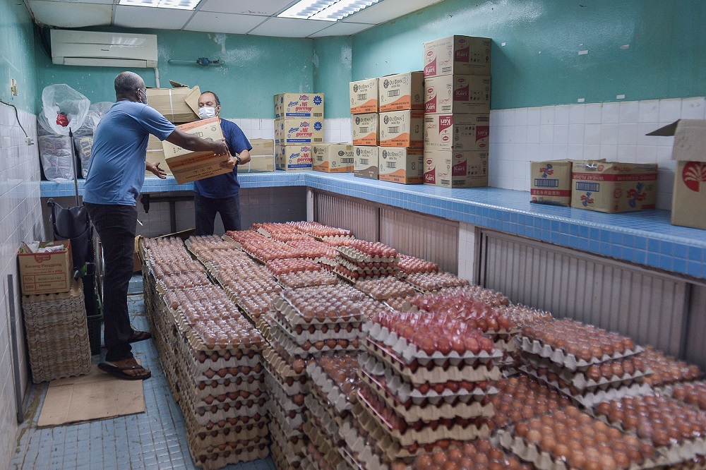 Workers at a food bank arrange the items to be given to the needy in conjunction with the White Flag Relief Mission and Vegetable Distribution in Port Klang July 7, 2021. x