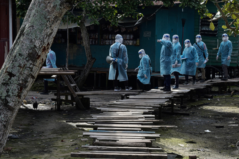 Health workers with police and Labuan Disaster Management Committee members garbed in PPEs while conducting house-to-house active case detection at the squattersu00e2u20acu2122 settlement in Kampung Saguking recently, July 18, 2021. u00e2u20acu201d Bernama pic  