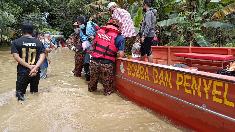 Fire and Rescue Department personnel assisting flood victims evacuated to the PPS at SJK (C) Chung Hua Trusan. u00e2u20acu2022 Borneo Post pic