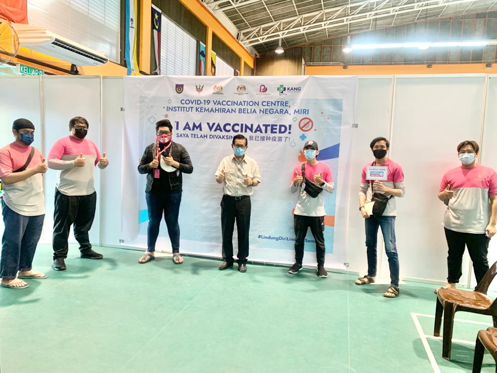 Lee (centre) joins the Food Panda delivery riders in a photo-call, taken after they have received their Covid-19 vaccines at the PPV in IKBN Miri. u00e2u20acu2022 Borneo Post pic