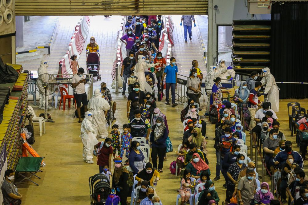 People queue as they wait to enter the Covid-19 Assessment Centre at the Malawati Stadium in Shah Alam July 14, 2021. u00e2u20acu201d Picture by Yusof Mat Isa