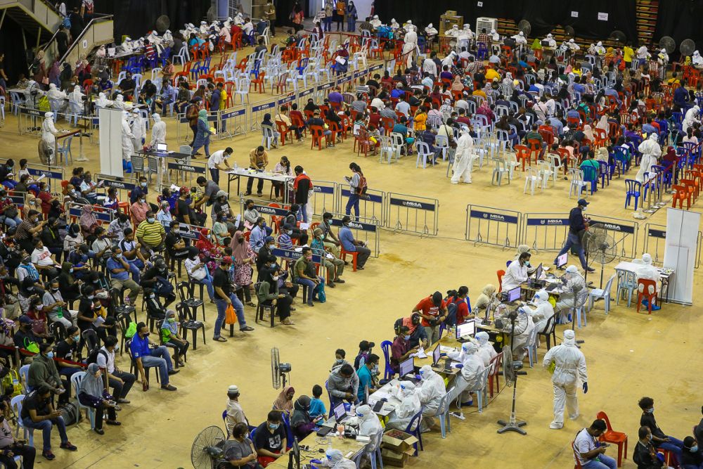 People wait to register their personal details before entering the Covid-19 Assessment Centre at the Malawati Stadium in Shah Alam July 14, 2021. u00e2u20acu201d Picture by Yusof Mat Isa