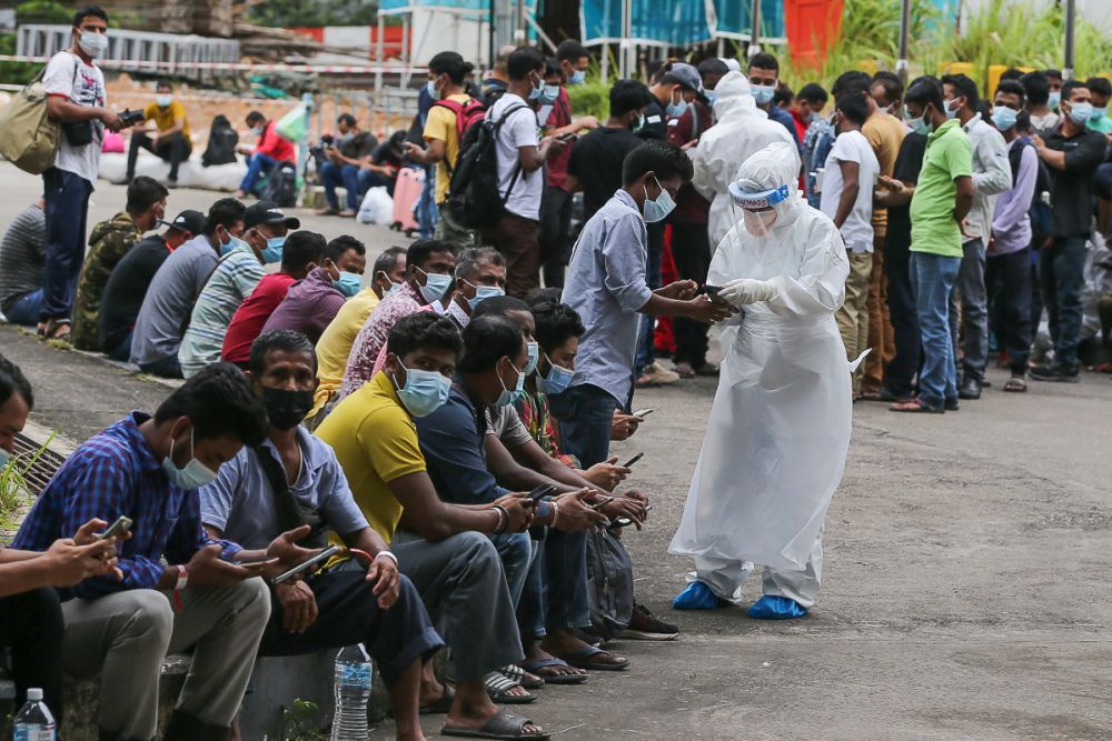 Foreign workers are seen waiting outside the Covid-19 Assessment Centre at the Malawati Stadium in Shah Alam July 14, 2021. u00e2u20acu201d Picture by Yusof Mat Isa