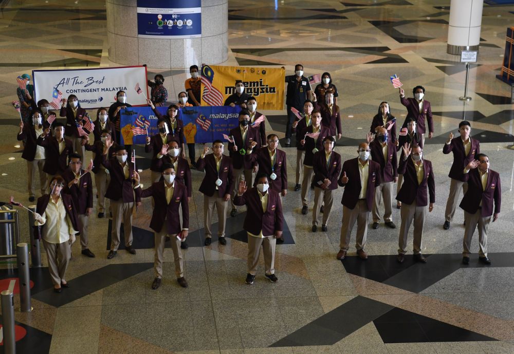Malaysian athletes wave goodbye before leaving for the 2020 Tokyo Olympic Games at the Kuala Lumpur International Airport July 17, 2021. u00e2u20acu201d Bernama picn