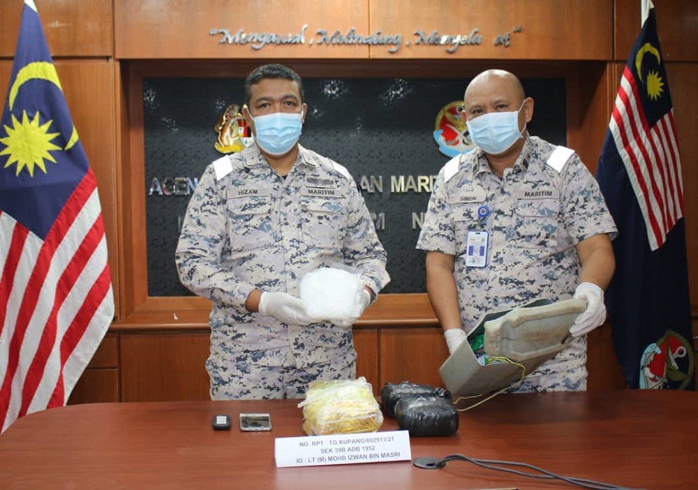 Johor MMEA director First Maritime Admiral Nurul Hizam Zakaria (left) showing the seized syabu illicit drugs by the MMEA team at the waters off Pulau Merambong yesterday July 22, 2021. u00e2u20acu201d Picture courtesy of the Johor MMEA